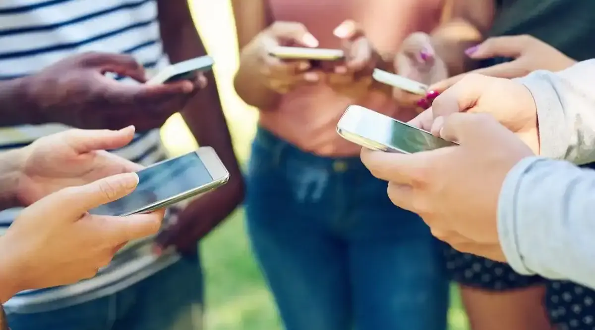 Jeunes en cercle tenant chacun leur smartphone