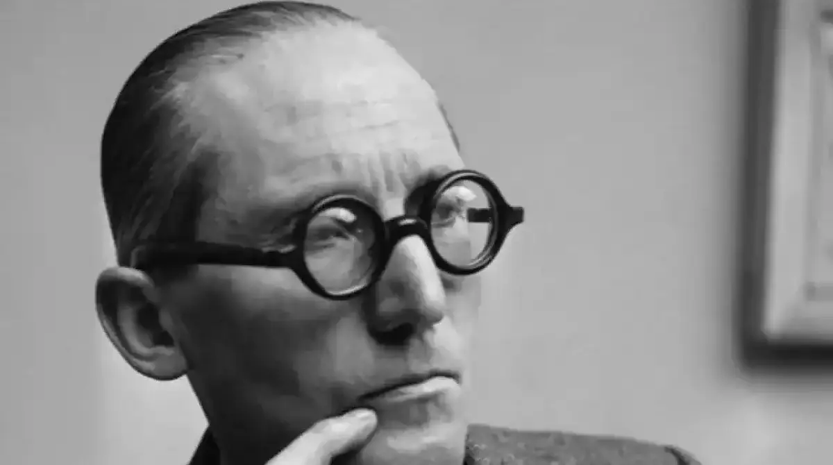 Photo noir et blanc de Le Corbusier, dans la cinquantaine avec des grosses lunettes rondes