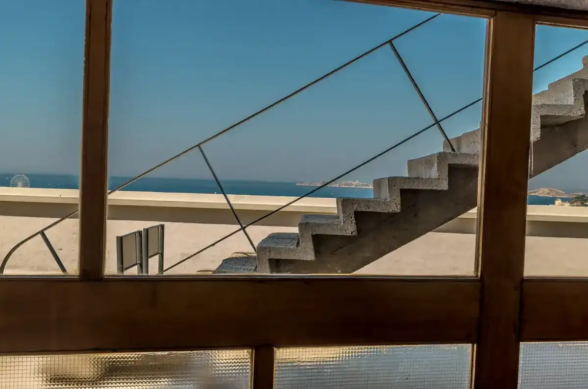 Vue sur la mer depuis l'intérieur du dernier étage, derrière un escalier en béton